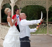 Groom sabrages champagne for his bride at Quex